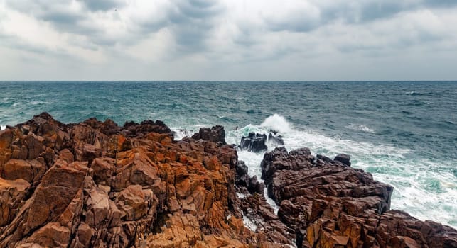 Picturesque seascape panorama. Waves breaking over rocks. Stormy sea. Coastline of the old town of Sozopol. Bulgarian Black Sea coast.