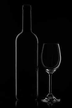 Silhouette of wine bottle and empty wineglass on a black background with reflection. Contour with gradient and highlights