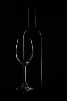 Silhouette of wine bottle and empty wineglass on a black background with reflection. Contour with gradient and highlights