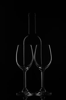 Silhouette of wine bottle and two empty wineglasses on a black background with reflection. Contour with gradient and highlights