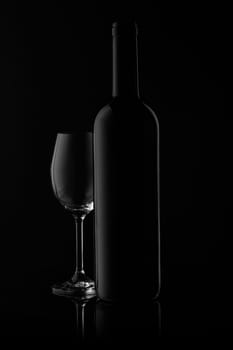 Silhouette of wine bottle and empty wineglass on a black background with reflection. Contour with gradient and highlights