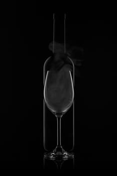 Silhouette of wine bottle and empty wineglass on a black background with reflection. Contour with gradient and highlights