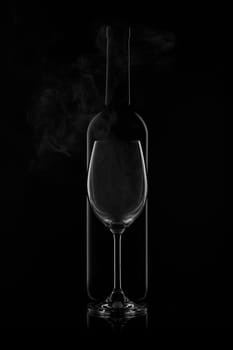 Silhouette of wine bottle and empty wineglass on a black background with reflection. Contour with gradient and highlights