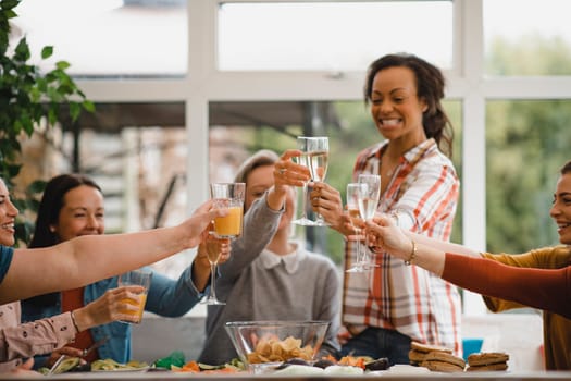Small group of female friends preparing a healthy lunch inside of a conservatory on a weekend away.
