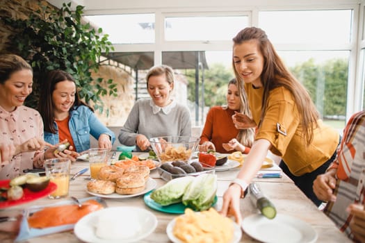 Small group of female friends preparing a healthy lunch inside of a conservatory on a weekend away.