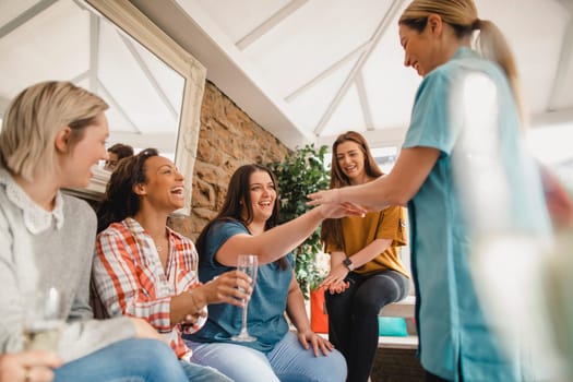 Mid adult beauty sales representative making a sales pitch to a group of women at a product party.
