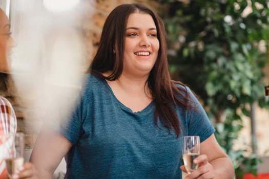 Young female adult showing happiness and excitement while celebrating at a party with champagne.