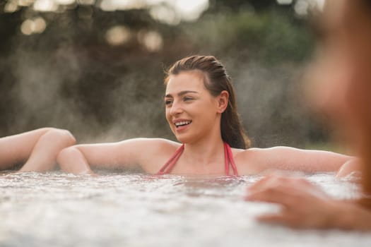 Mid adult woman relaxing in a hot tub with her friends.