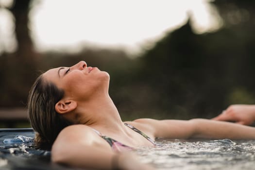 Mid adult woman relaxing in a hot tub with her friends.
