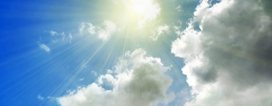Rays of streaming sunlight on cloudy blue sky background. Summer, holiday, fun, banner, nature, concept.