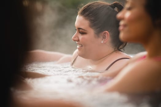 Mid adult woman relaxing in a hot tub with her friends.