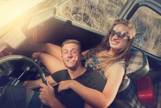 Young couple in a retro car at sunset, retro style.