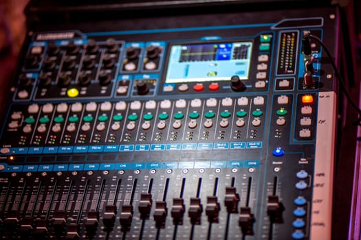 Closeup of musical amplifier. Sound amplifier or music mixer in multicolored light.