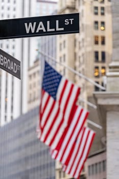 Wall street sign with New York Stock Exchange background New York City, New York, USA.