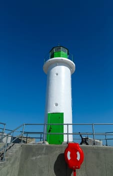 White lighthouse tower on blue sky background, Ventspils, Latvia