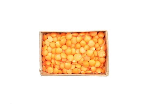 Red lentils in carton and white background
