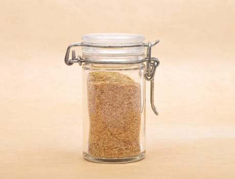 Wheat germs in closed jar on brown background