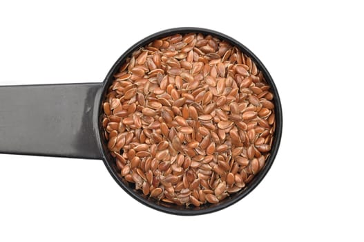 Linseed in measuring spoon on white background