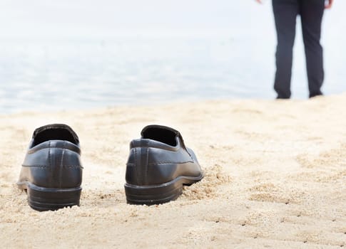 Businessman take off his shoes on the beach. Summer vacation