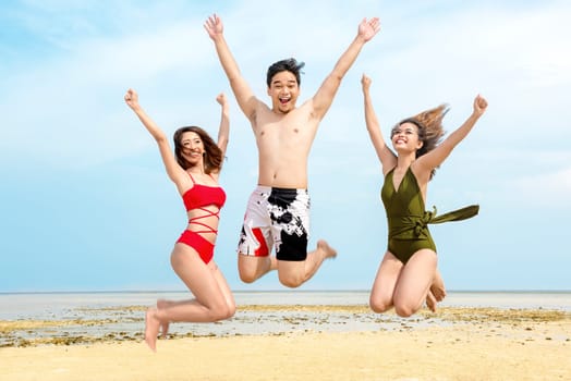 Group of asian friends having fun and jump together on the beach. Summer vacation
