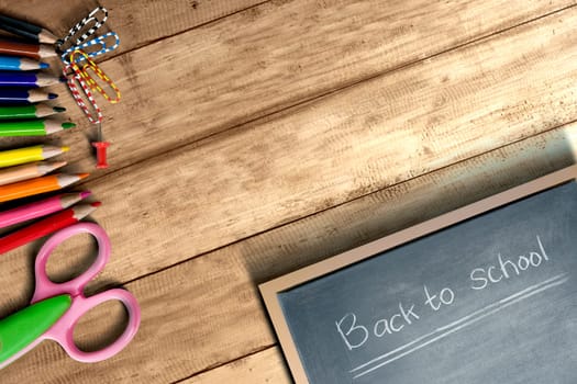 School supplies and stationery with little blackboard with Back to School text on wooden table. Back to School concept