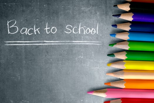 Row of colorful stationery of pencils for drawing on blackboard with Back to School message. Back to School concept