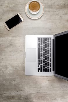 Top view of business desk with laptop, coffee and mobile phone on the office