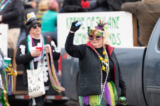 St. Louis, Missouri, USA - March 2, 2019: Bud Light Grand Parade, Woman celebrating mardi gras, walking down 7th street during the parade