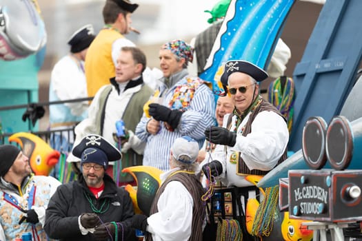 St. Louis, Missouri, USA - March 2, 2019: Bud Light Grand Parade, A float in shape of a shark carrying people dress up as pirates, throwing beads to the spectators