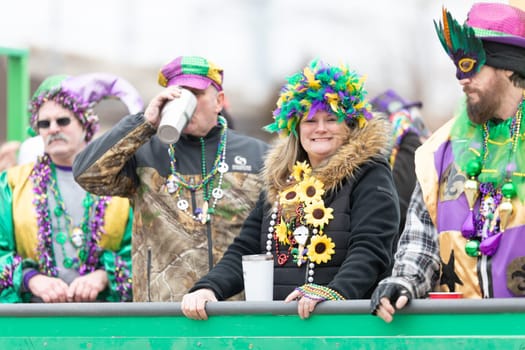 St. Louis, Missouri, USA - March 2, 2019: Bud Light Grand Parade, woman wearing a colorful feather hat looking and smiling at the camera