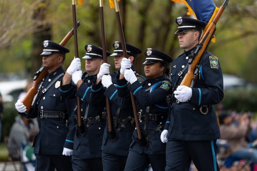 Wilmington, North Carolina, USA - April 6, 2019: The North Carolina.Azalea Festival, Wilmington police officers marching with the american flag during the parade