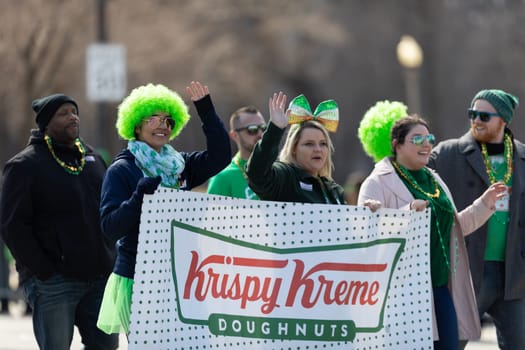 Chicago, Illinois, USA - March 16, 2019: St. Patrick's Day Parade, Women promoting Krispy Kreme Doughnuts at the parade