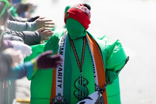 Chicago, Illinois, USA - March 16, 2019: St. Patrick's Day Parade, Two Children dress up as trebols runing towards the spectators during the parade