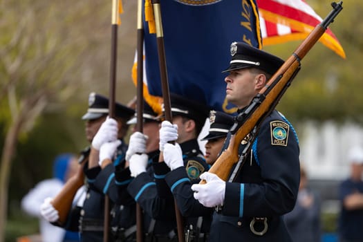 Wilmington, North Carolina, USA - April 6, 2019: The North Carolina.Azalea Festival, Wilmington police officers marching with the american flag during the parade