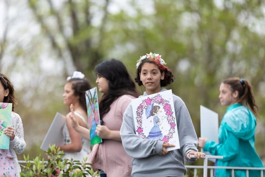 Wilmington, North Carolina, USA - April 6, 2019: The North Carolina.Azalea Festival, Young girls holding their art work, riding a float down the street at the parade