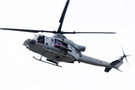 Louisville, Kentucky, USA - April 13, 2019: Thunder Over Louisville, United States Marine Corps uh-1 displaying an American Flag Making a fly by over the Ohio River