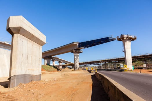 New Road highway expansion construction industrial building of overhead ramps concrete columns to traffic vehicle junction.