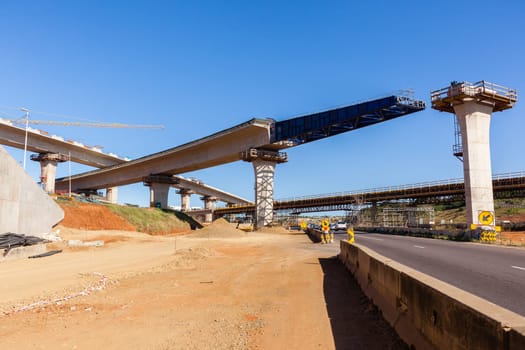 New Road highway expansion construction industrial building of overhead ramps concrete columns to traffic vehicle junction.