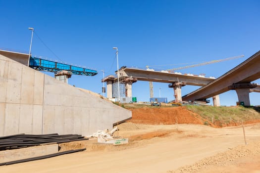 New Road highway expansion construction industrial building of overhead ramps concrete columns to traffic vehicle junction.