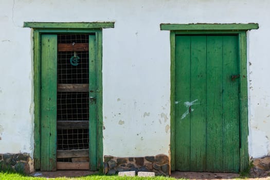 Vintage door wood frames in farm wall outside storeroom structure