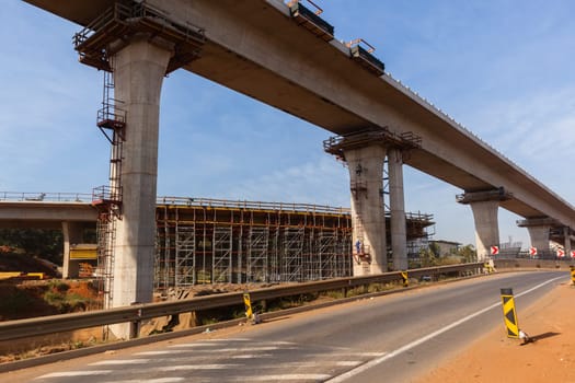 New Road highway expansion construction industrial building of overhead ramps concrete columns to traffic vehicle junction.