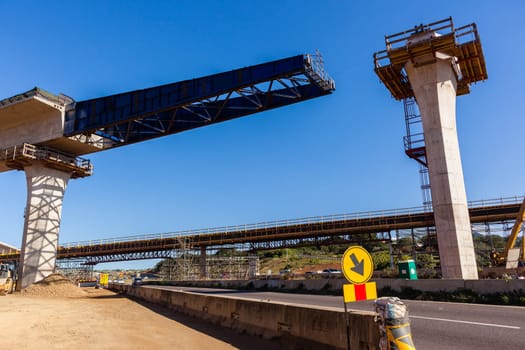 New Road highway expansion construction industrial building of overhead ramps concrete columns to traffic vehicle junction.