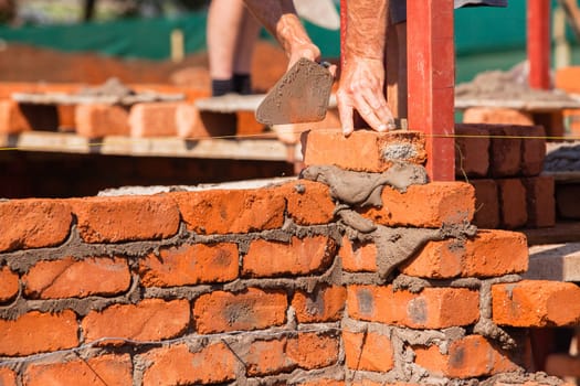 Building construction artisan hands tool laying bricks closeup cement wire wall construction