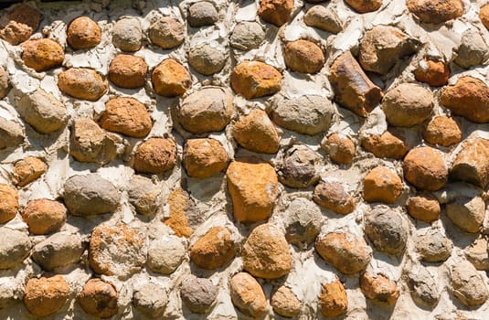 Building outside walls built with river stones natural resources closeup detail textures background structure.