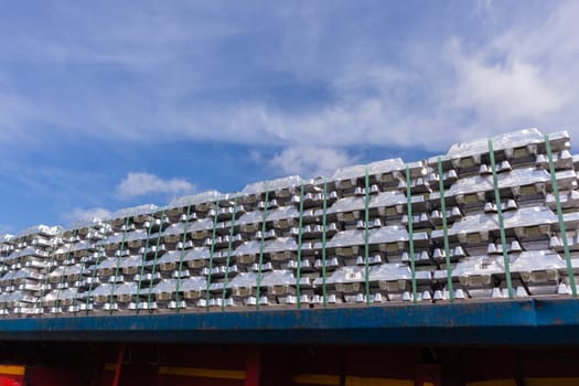 Aluminum ingots industrial materials stacked on truck transport trailer from refinery to factory processing manufacture products.