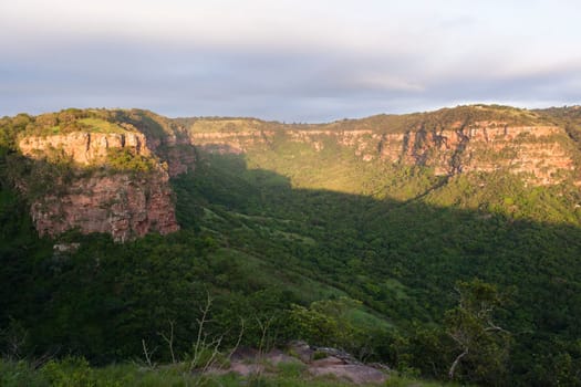 Wilderness overlooking hiking landscape valley gorge rocky cliffs summer morning.