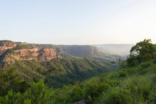 Wilderness overlooking hiking landscape valley gorge rocky cliffs summer morning.