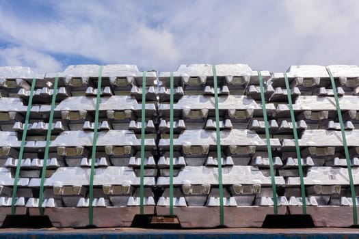 Aluminum ingots industrial materials stacked on truck transport trailer from refinery to factory processing manufacture products.
