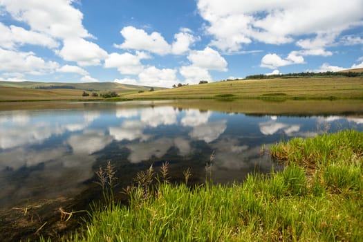 Lake summer blue sky cloud reflections on glassy water scenic mountain landscape