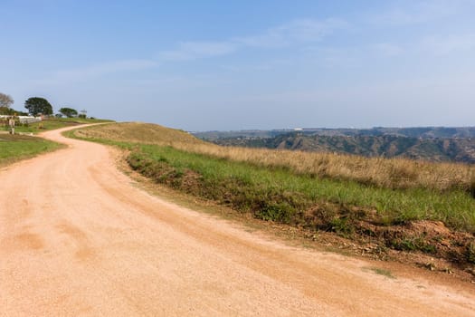 Dirt gravel road route on hillside sky rural countryside landscape